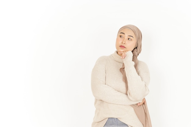 Denkend gebaar van mooie Aziatische vrouw die hijab draagt die op witte achtergrond wordt geïsoleerd