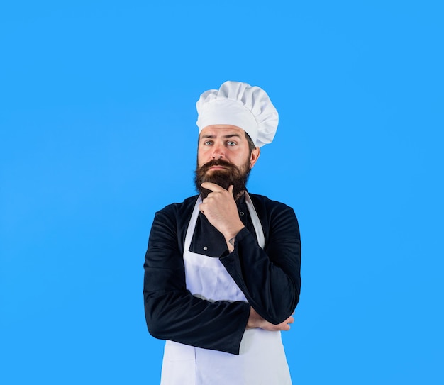 Denkende chef-kok die een nieuw menu samenstelt, bebaarde man in witte hoed en schort mannelijke chef-kok of bakker in