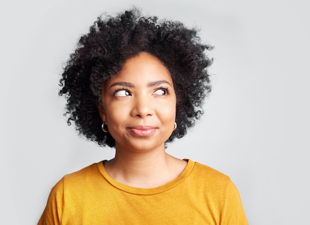 Denkende nieuwsgierige en Afrikaanse vrouw in studio met ideebeslissing of keuze tegen grijze achtergrond Ideecontemplatie en vrouwelijke keuze onzeker en zich afvragend beslissen en nadenken terwijl ze geïsoleerd zijn