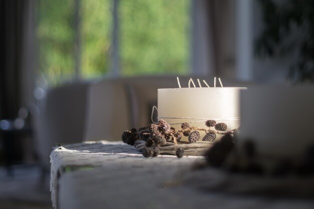 Dennenkegel met kaars op tafel.