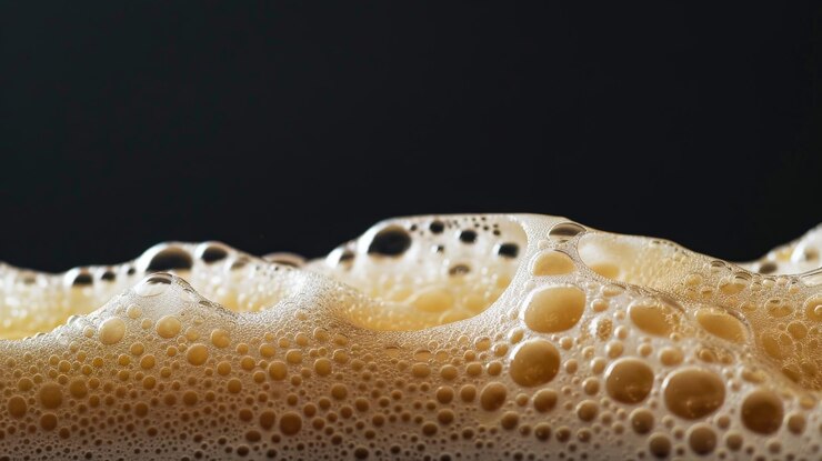 Photo dense beer foam in high resolution with a black background to accentuate the purity and texture of the foam
