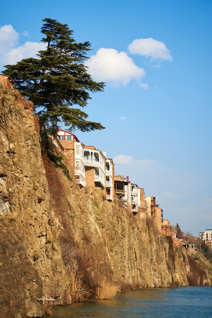 Dense development of a residential building on a cliff by the river.