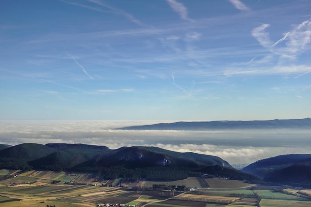 Dense fog in the valley during hiking in the sunshine and blue sky