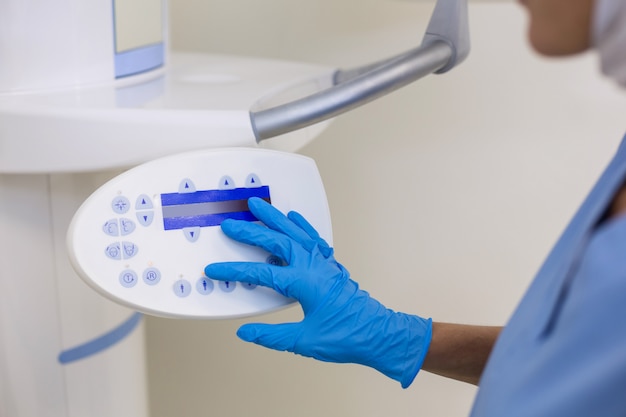 Dental assistant adjusting x-ray equipment