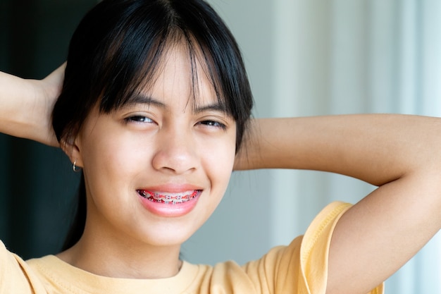 Фото Стоматологическая скоба девушка улыбается и смотрит в камеру, она чувствует себя счастливой и имеет хорошее отношение к стоматологу. мотивируйте детей не бояться, когда им нужно идти в стоматологическую клинику.