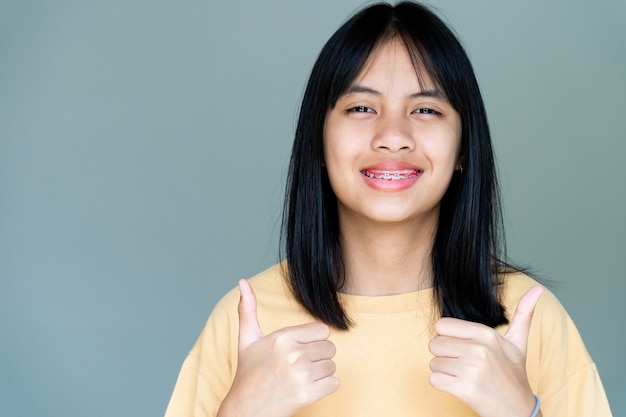 Ragazza con apparecchio dentale che sorride e guarda la telecamera, si sente felice e ha un buon atteggiamento con il dentista. motivare i bambini non temono quando devono andare in clinica odontoiatrica.