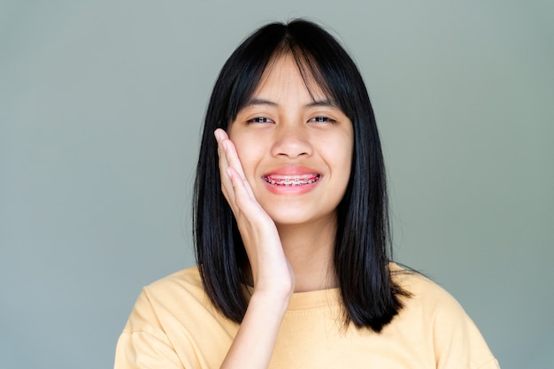 Ragazza con apparecchio dentale che sorride e guarda la telecamera, si sente felice e ha un buon atteggiamento con il dentista. motivare i bambini non temono quando devono andare in clinica odontoiatrica.