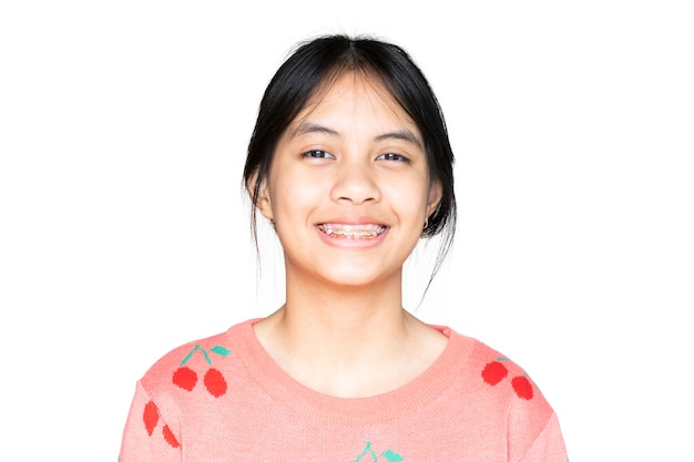 Photo dental brace girl smiling and looking to camera on white background, she feel happy and have good attitude with dentist.  motivate kids not fear when they have to go to dental clinic.