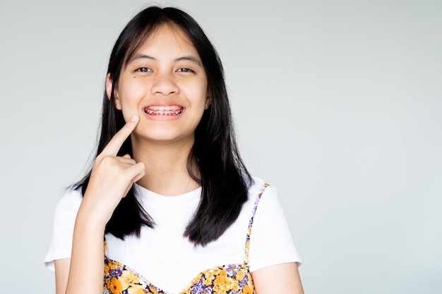 Dental Brace Girl Smiling and Looking to Camera on White Background, She Feel Happy and Have Good Attitude with Dentist.  Motivate Kids not Fear When they have to go to Dental Clinic.