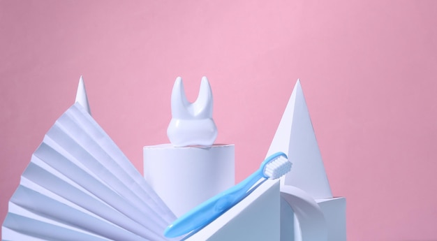 Dental care concept Tooth and toothbrush on a showcase with geometric shapes Pink background