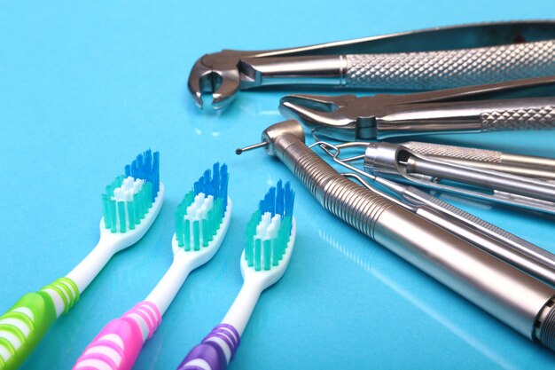 Dental care toothbrush with dentist tools on mirror background.