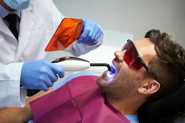 Photo dental clinic patient having his teeth treated with laser