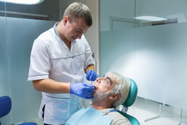 Dental doctor with senior patient elderly male at the dentist professionalism in medicine