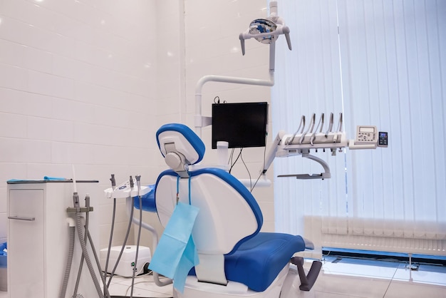 Apparecchiature odontoiatriche nella sala di odontoiatria nel nuovo e moderno ufficio della clinica stomatologica sfondo della poltrona odontoiatrica e degli accessori