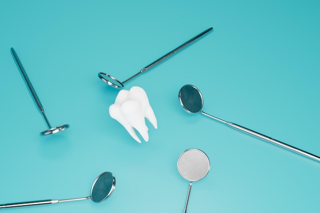 Dental examination a tooth around which dental mirrors on a turquoise background 3D render