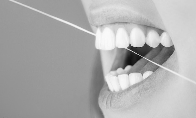 치실 치아 관리 건강한 치아 개념 치아 치실 웃는 여성은 치과를 사용합니다
