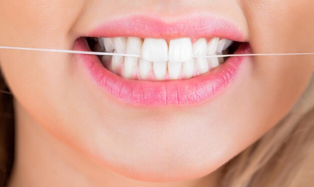dental floss taking care of teeth teeths flossing dental flush woman flossing teeth oral hygiene and health care smiling women use dental floss white healthy teeth
