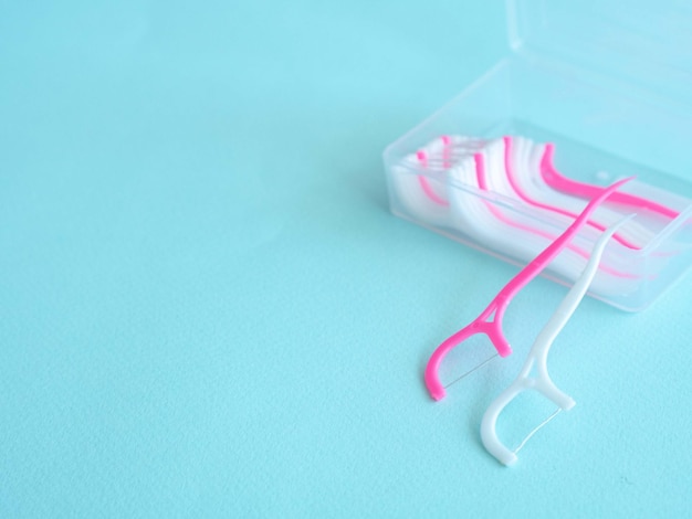 Photo dental floss with a plastic toothpick in a container with a place for text