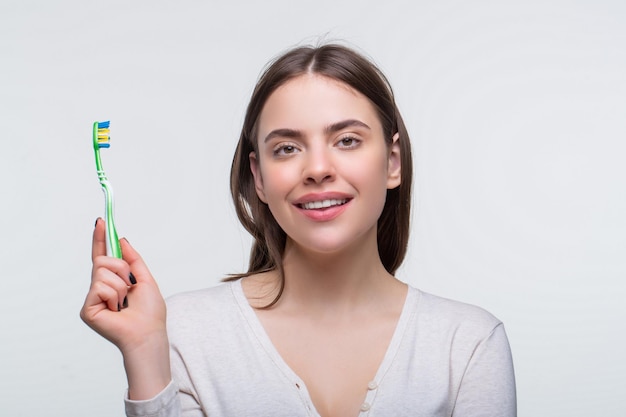 Dental health background Close up of perfect and healthy teeth with toothbrush Portrait of a smiling cute woman holding toothbrush Smiling woman with healthy beautiful teeth holding a toothbrush