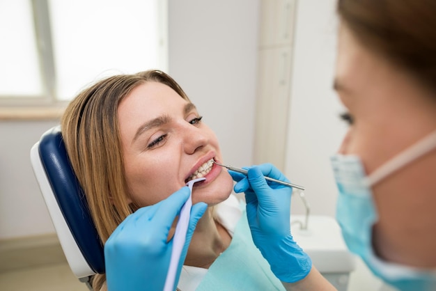 Dental health concept photo of a smiling female patient being\
treated in a dental clinic