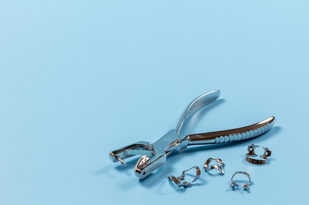 Dental hole punch and clamps on blue