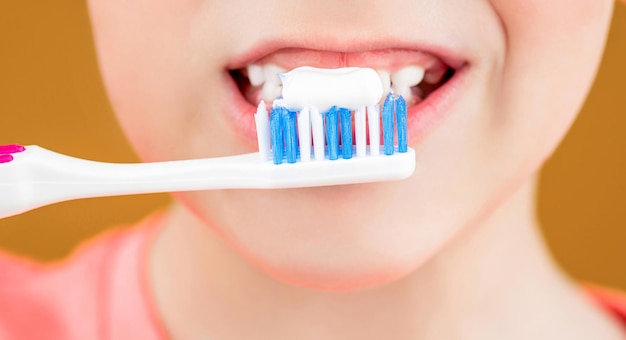 Dental hygiene happy little kid brushing her teeth health care\
dental hygiene kid boy brushing teeth boy toothbrush white\
toothpaste joyful child shows toothbrushes little boy cleaning\
teeth