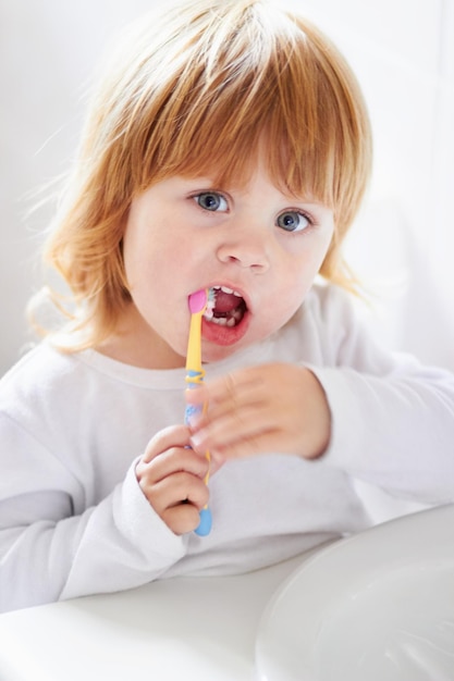 Dental hygiene at a young age Portrait of a cute baby brushing her teeth