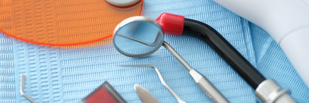 Dental instruments and denture lie on a blue medical napkin