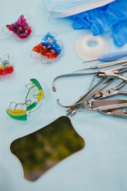 Dental instruments and dentures on medical table. Laboratory instruments for treatment and model of teeth on blue background. Prosthetist's office. Concept of examination to hygienist. Copy space