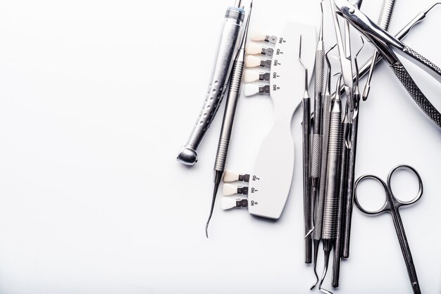 Dental metal tools on white table with copy space