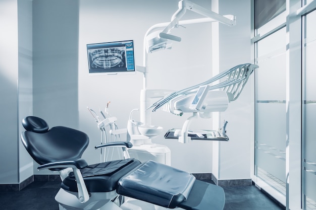 Photo dental office with dental chair computer and dentist tools