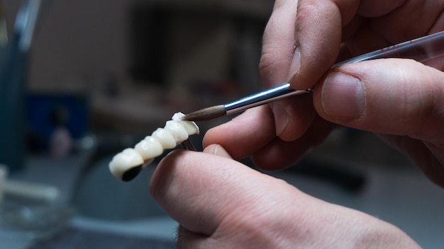 Dental technician creates dental prostheses laboratory closeup