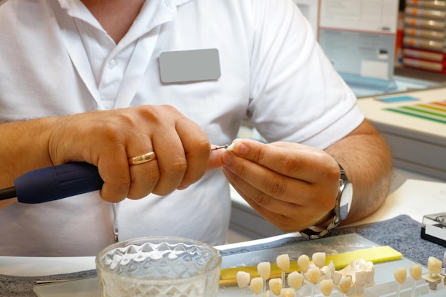 Foto odontotecnico o dentista che lavora con dentiere nel suo laboratorio