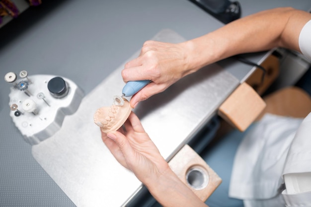 Dental technician making dental prosthesis looking better