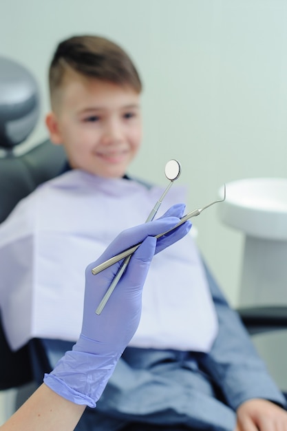 Dental tools in focus. A child boy with a dentist in a dental office.