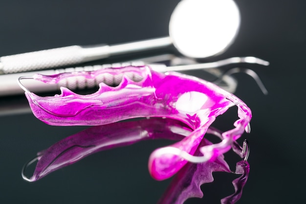 Dental tools and retainer orthodontic appliance on the black background