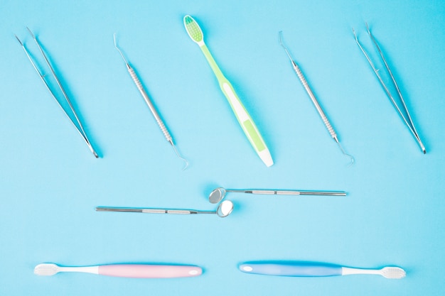 Dental tools use for dentist on the blue background, flat lay, top view.