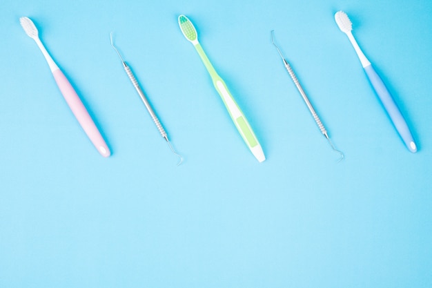 Dental tools use for dentist on the blue background, flat lay, top view.