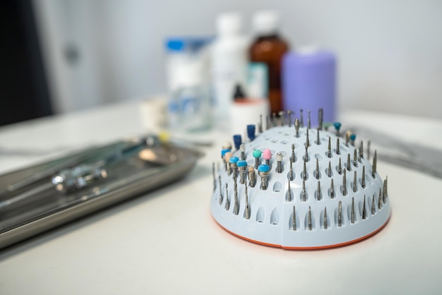 Dental tweezers lie in a metal tray and a bunch of other parts