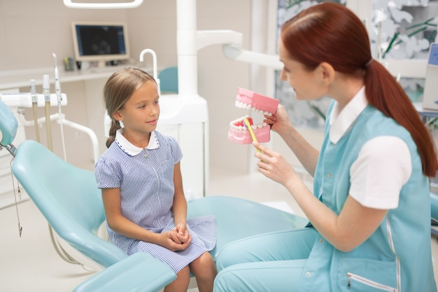 Dentist after school. Schoolgirl wearing nice dress coming to child dentist after school