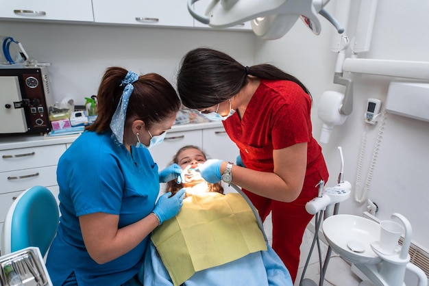 Dentist appointment at a dental clinic placing braces locks on the teeth and pulling the archwire to fix it