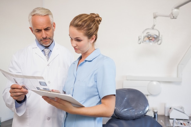 Photo dentist and assistant studying x-rays