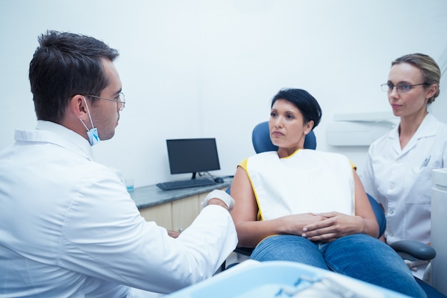 Dentist and assistant with female patient