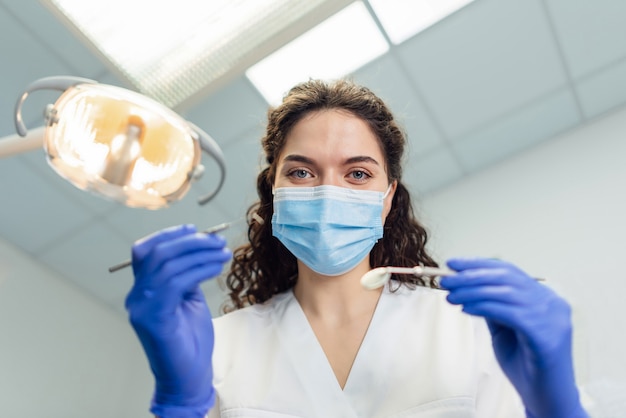 Foto il dentista si chinò sul paziente che teneva lo strumento tra le mani