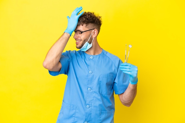 Dentist blonde man holding tools isolated on background has realized something and intending the solution