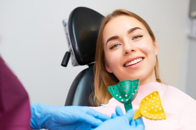 Photo a dentist carefully chooses plastic molds for taking impressions to create alignments