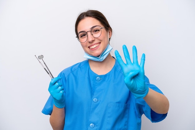 Dentist caucasian woman holding tools isolated on white background happy and counting four with fingers