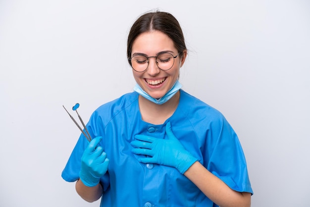 Dentist caucasian woman holding tools isolated on white background smiling a lot