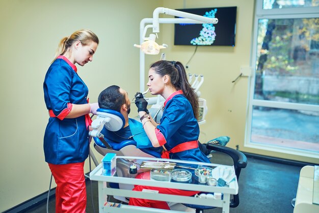 Dentist and dental nurse using dental equipment