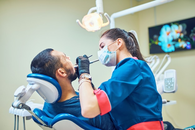 Dentist and dental nurse using dental equipment